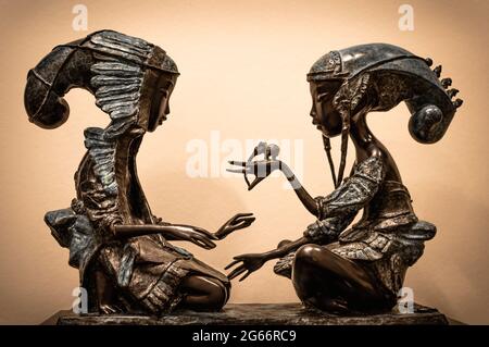 Ancienne figurine de deux femmes orientales qui parlent l'une à l'autre. Banque D'Images