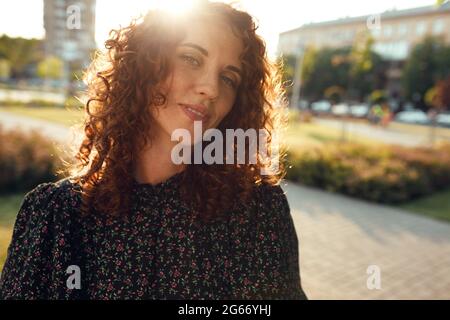 charmante jeune fille aux cheveux rouges et aux poils rouges avec des taches de rousseur dans la robe pose pour la caméra dans le centre-ville montrant différentes émotions faciales Banque D'Images