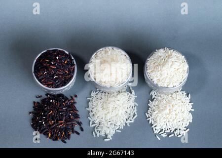 Trois types de riz dans un récipient en argent. Sur un arrière-plan gris et un espace de copie. Banque D'Images