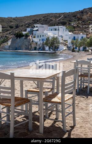 Taverne en plein air de l'île grecque. Table et chaises de taverne typique en bord de mer. Places vides, journée ensoleillée au restaurant de poissons et fruits de mer de Kimolos. Aspirateur d'été Banque D'Images