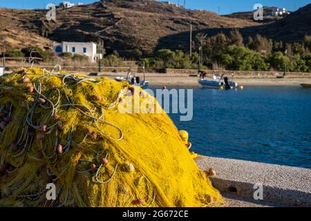 Les filets de pêche se empilent sur le quai du port de pêcheur et sèchent sous le soleil. Des résilettes de couleur jaune avec des cordes et des flotteurs sur l'île grecque iOS, Cyclades Grèce de retour Banque D'Images