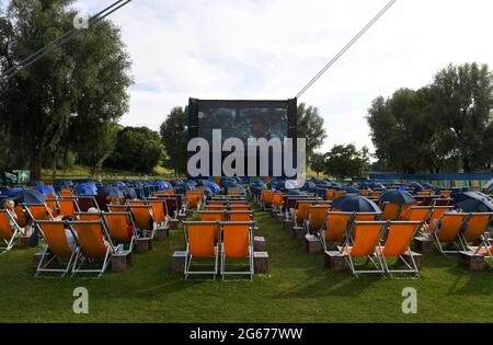 Munich, Allemagne. 03ème juillet 2021. Les spectateurs s'assoient avec des parasols au cinéma à l'Olympiasee (en plein air) ce soir, la première du film « la fille aux mains d'or » y a lieu dans le cadre du Filmfest international de Munich. Credit: Felix Hörhager/dpa/Alay Live News Banque D'Images