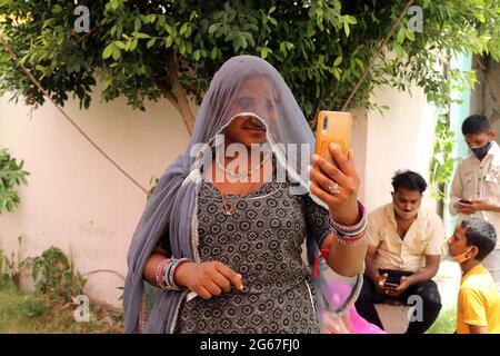 Beawar, Rajasthan, Inde, 3 juillet 2021 : une femme Rajasthani en voile prend un selfie sur téléphone mobile après avoir reçu la première dose du vaccin COVID-19 dans un centre de vaccination de Beawar. Crédit : Sumit Saraswat/Alay Live News Banque D'Images