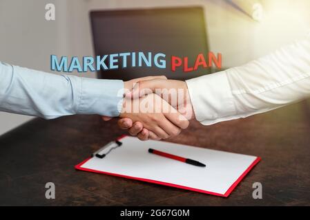 Légende présentant le plan marketing. Mot pour la stratégie commerciale globale formée, qui mettra en œuvre deux professionnels bien habillés entreprise Banque D'Images
