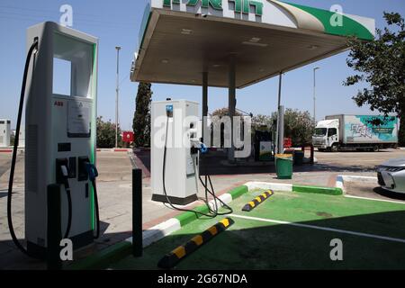 Deux bornes de recharge de voiture électrique avec des places de stationnement vertes pour les voitures électriques seulement dans une station-service ou d'essence régulière. Banque D'Images