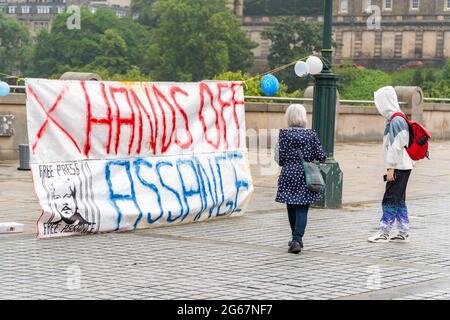 The Mound, Édimbourg, Écosse, Royaume-Uni, 3 juillet 2021 : membre du public, s'arrête et regarde, alors qu'il a marché devant la grande bannière Julian Assange au monticule. Les partisans de Julian Assange sont descendus dans les rues d’Édimbourg pour souligner le 50e anniversaire de Julian, une des nombreuses célébrations qui ont lieu aujourd’hui dans le monde entier. Julian Assange est toujours détenu à la prison de Belmarsh, alors que le gouvernement américain tente de l'extrader vers l'Amérique, pour les publications d'informations divulguées sur son site Web de wikileaks. (Crédit : Barry Nixon/Alamy Live News) Banque D'Images