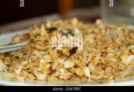 Gros plan image de l'aval sucrée du Kerala Nanachathu ou des flocons de riz sucré Poha dans une assiette. Mise au point sélective Banque D'Images