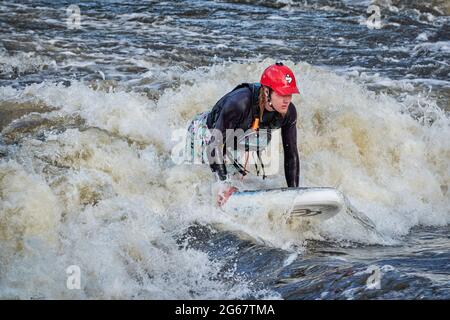 Fort Collins, Colorado, États-Unis - 7 mai 2021 : un jeune homme surfait sur une vague dans le parc de la rivière poudre Whitewater. Banque D'Images