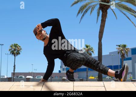 Jeune latino-américain danseur acrobatique urbain dans la rue faisant un spectacle. Banque D'Images