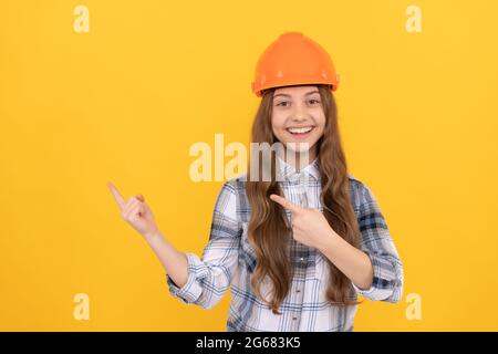 jeune fille dans un casque. enfant de constructeur dans une chemise à carreaux. concept de construction et de construction. Banque D'Images