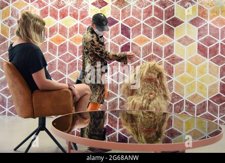 01 juillet 2021, Saxe, Leipzig: Dans l'exposition 'Appointment X' à la Galerie d'art contemporain, qui est annoncée comme une expérience, les visiteurs regardent d'autres objets fabriqués avec de la nourriture sucrée collante dans la salle 'Stick with Me', devant une mosaïque de confiture qui remplit les murs. Le projet expérimental, dans lequel les objets peuvent être touchés, est destiné à faciliter les points communs interactifs, les tristes, les rencontres avec ce certain, quelque chose inconnu. Photo: Waltraud Grubitzsch/dpa-Zentralbild/ZB - ATTENTION: Pour usage éditorial seulement dans le cadre de la couverture actuelle de l'exposition Appointment X et seulement Banque D'Images