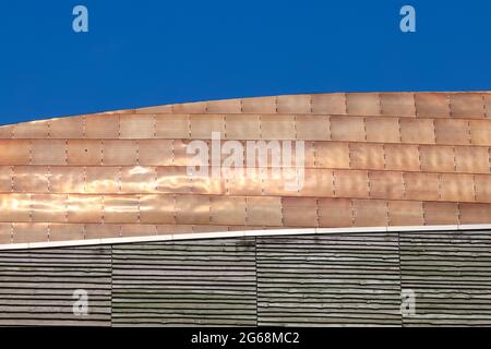 Tuiles de toiture en alliage de bronze doré qui brillent sous le soleil d'été contre un ciel bleu clair Banque D'Images