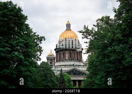 Cathédrale Saint Isaac à Saint-Pétersbourg, Russie. Le dôme de la cathédrale est visible à travers la couronne verte des arbres Banque D'Images