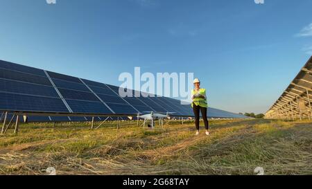 Technicien et investisseur utilisant la technologie de drone infrarouge pour inspecter les panneaux solaires et les éoliennes dans la ferme de cellules solaires, les cellules solaires seront un important Banque D'Images