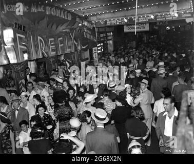 Foule de cinéastes devant l'entrée du THÉÂTRE ASTOR à New York en septembre 1937, sous la direction de JEANETTE MacDonald ALLAN JONES et WARREN WILLIAM dans LE réalisateur FIREFLY 1937 ROBERT Z. LEONARD basé sur la pièce de musique Otto A. Harbach Rudolf Friml producteur Hunt Stromberg Metro Goldwyn Mayer Banque D'Images