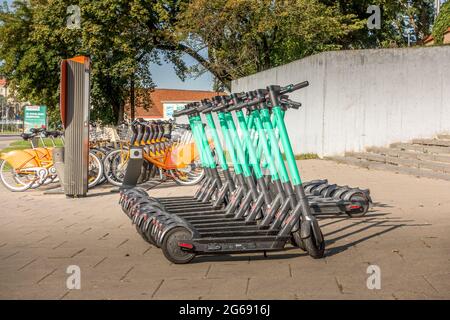 Vilnius, Lituanie - 22 septembre 2020 : scooters électriques et vélos orange alignés dans le point de location de la rue Vilnius. Transport écologique moderne Banque D'Images