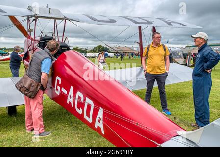 Les passionnés d'aviation inspectent une Moth rouge 1933 de Havilland Tiger lors du spectacle aérien Middle Wallop Wheels and Wings dans le Hampshire, au Royaume-Uni Banque D'Images