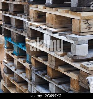 Une pile de vieilles palettes en bois pour le chargement. Logistique et livraison de fret. Arrière-plan carré Banque D'Images