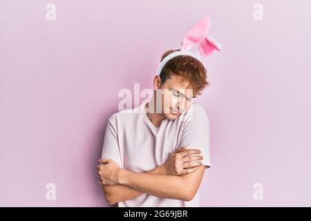 Jeune homme caucasien portant des oreilles de lapin de pâques mignonnes se embrassant heureux et positif, souriant confiant. Amour de soi et soin de soi Banque D'Images