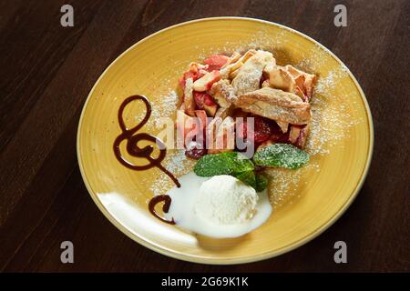 Strudel aux fruits avec une cuillère de crème glacée Banque D'Images