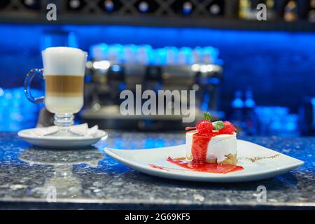 Une tasse de café-Latte frais chaud servi avec un délicieux dessert Banque D'Images