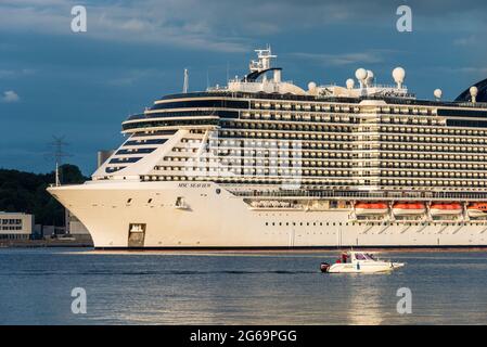 Auslaufen des Kreuzfahrtschiffes MSC Seaview in der abendlichen Kieler Förde, begleitet von einem Motorboot Banque D'Images