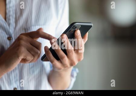 Gros plan femme tenant le smartphone en main, en tapant à l'écran Banque D'Images