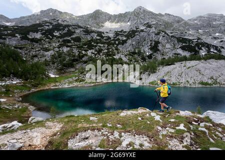 Garçon en blouson jaune randonnée au bord du lac du rein, Parc national de Triglav, Slovénie Banque D'Images