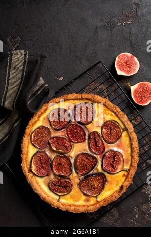 Tarte à la quiche maison avec figues, fromage à la crème et miel sur fond brun foncé. Style vintage. Vue de dessus Banque D'Images