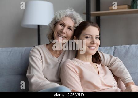 La grand-mère de la femme à la retraite s'assoit sur le canapé-lit petite-fille adulte Banque D'Images