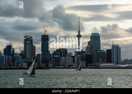 Célèbre horizon du quartier central des affaires d'Auckland au coucher du soleil, les gens se réjouissant de la chaude soirée d'été sur leurs voiliers, Nouvelle-Zélande Banque D'Images