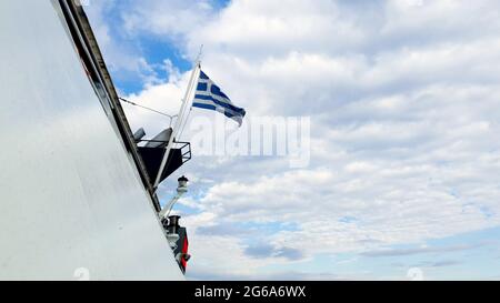 Drapeau grec agitant à l'arrière d'un navire dans l'océan Banque D'Images