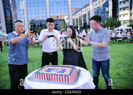 Pékin, Chine. 04e juillet 2021. Les gens prennent des photos d'un gâteau au barbecue annuel de la Chambre de commerce américaine (AmCham) du 4 juillet à Beijing, le dimanche 4 juillet 2021. Malgré les tensions actuelles entre Washington et Beijing, les entreprises américaines travaillent encore en étroite collaboration avec le gouvernement chinois pour améliorer le commerce et la coopération commerciale. DOCUMENT photo AMCHAM/UPI crédit: UPI/Alamy Live News Banque D'Images