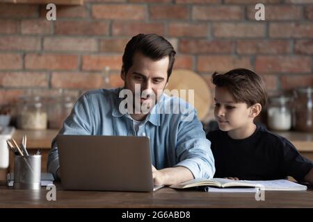 Meilleur papa aidant le fils d'un garçon d'école, expliquant les devoirs à l'école à l'enfant Banque D'Images