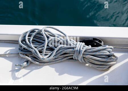 Cordes d'amarrage sur le fond du pont de bateau à voile. Corde de yachting de couleur grise sur l'arc du navire, vue rapprochée, croisière avec Voilier en mer Egée, Grèce Banque D'Images