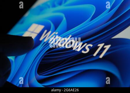 Le logo Windows 11 apparaît sur l'écran de la tablette et l'utilisateur le pointe avec le doigt. Stafford, Royaume-Uni, 1er juillet 2021 Banque D'Images