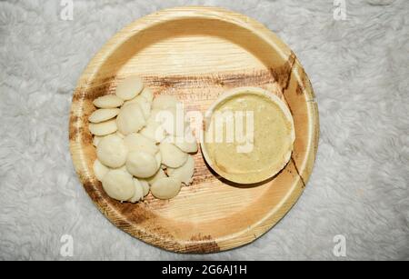 Délicieux Mini button idli avec Sambar chaud et chutney de cacahuètes mungfali servi dans des assiettes et des bols bio écologiques et jetables.South Indian petit déjeuner i Banque D'Images