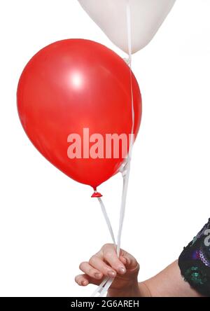 La main de la femme tient 2 ballons sur une corde rouge et de couleur claire sur un fond blanc, isolé. Banque D'Images