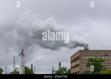 Ciel rempli de fumée polluant l'environnement d'une raffinerie. Banque D'Images