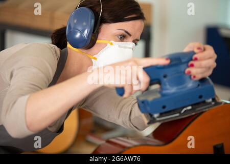 femme en gants sablant une guitare Banque D'Images
