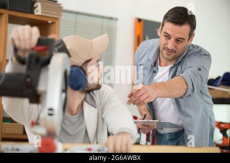 portrait de l'apprenti enseignant de menuisier senior debout dans l'atelier Banque D'Images