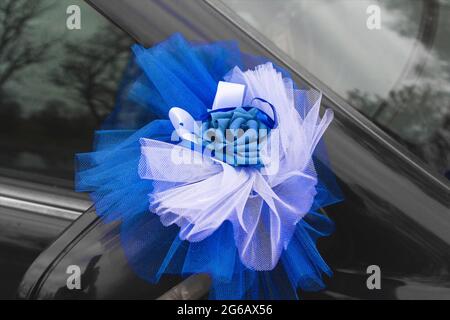 Décoration artificielle de voiture au mariage sous la forme d'un arc et d'une rose bleue, gros plan. Banque D'Images