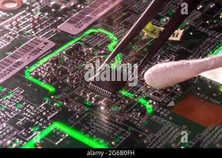 homme nettoyant le circuit électrique sale avec un tube de coton macro de la technologie concept Banque D'Images