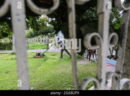 Gaza, Palestine. 04e juillet 2021. Un homme palestinien tond une pelouse dans un parc public de la ville de Gaza. (Photo de Mahmoud Issa/SOPA Images/Sipa USA) crédit: SIPA USA/Alay Live News Banque D'Images