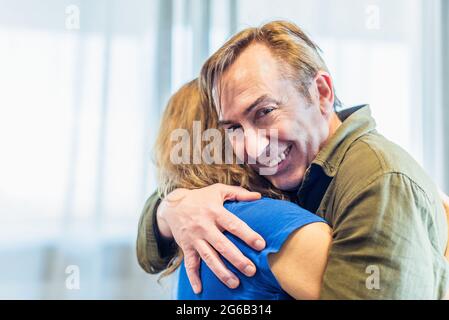 Homme et femme mûrs qui s'embrasse à la maison. Banque D'Images