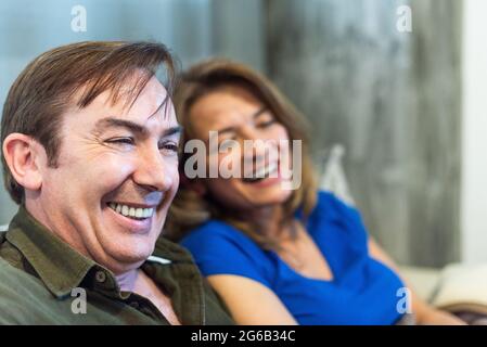 Homme et femme matures, souriant à la maison. Banque D'Images