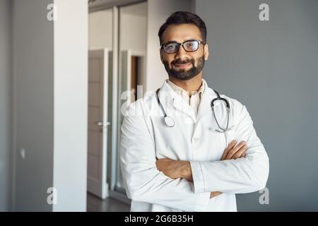 Portrait d'un médecin masculin en manteau blanc et stéthoscope debout dans le hall de la clinique Banque D'Images