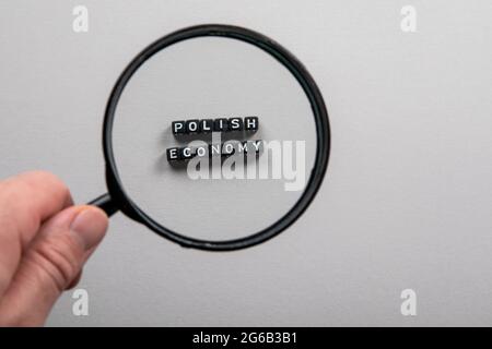 ÉCONOMIE POLONAISE. Loupe dans la main d'un homme. Banque D'Images