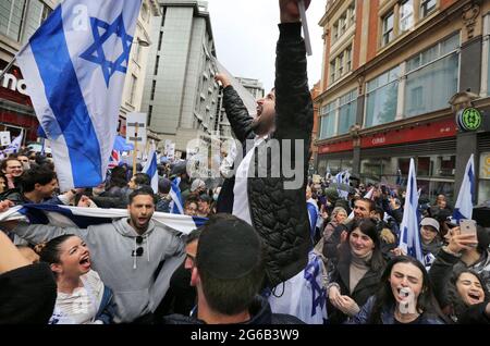 Londres, Royaume-Uni. 23 mai 2021. Un manifestant sur les épaules d'un ami scanne et fait signe un drapeau israélien pendant la manifestation.des manifestants pro-israéliens se rassemblent devant l'ambassade israélienne à High Street Kensington pour soutenir le cessez-le-feu convenu le 21 mai. Un petit groupe de Palestiniens se sont retournés contre-manifester la manifestation israélienne, mais la police a formé un cordon entre les deux foules pour éviter toute violence. (Photo par Martin Pope/ SOPA Images/Sipa USA) crédit: SIPA USA/Alay Live News Banque D'Images