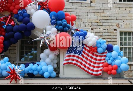 Présentation festive et lumineuse de ballons rouges, blancs et bleus avec le drapeau américain en évidence le jour de l'indépendance. Banque D'Images